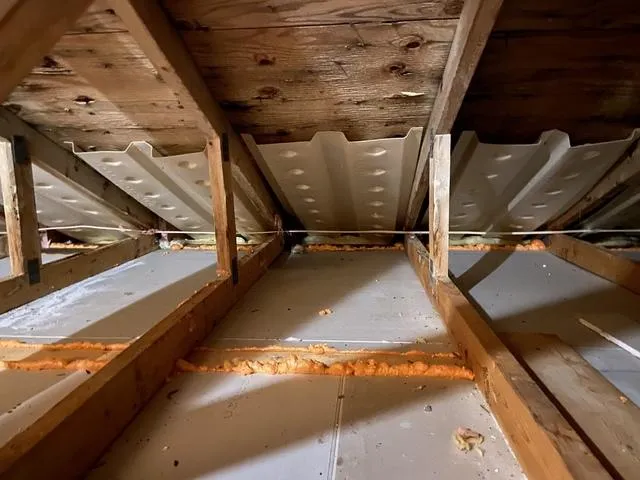 Attic rafter baffles with spray foam sealing at framing joints