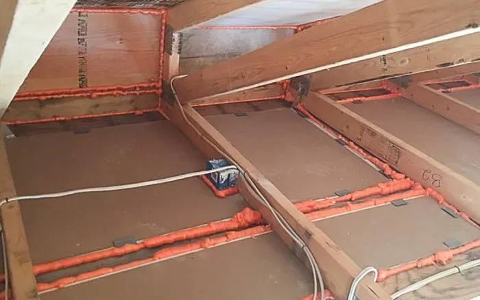 Spray foam air sealing applied along attic joist seams and framing connections