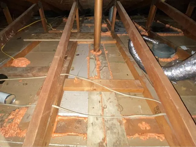 Spray foam sealing around pipe chase and framing in attic