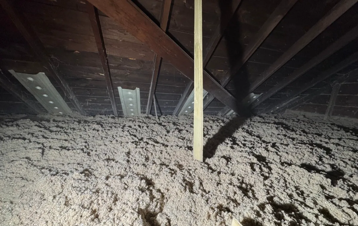 Attic insulation filling space around support beam and rafters - NY Energy Project