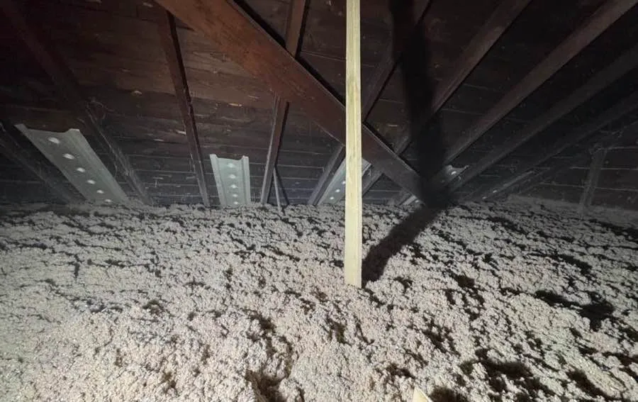 Attic insulation filling space around support beam and rafters - NY Energy Project