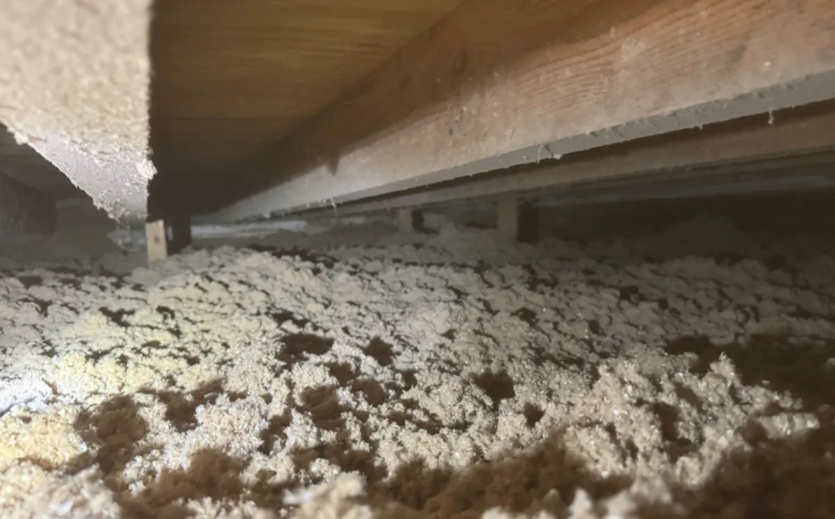 Low angle view of blown-in attic insulation between rafters - NY Energy Project completed job