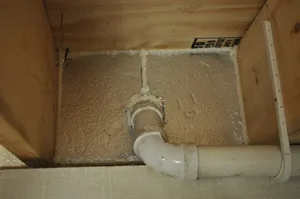 Spray foam insulation around plumbing penetrations in basement rim joist