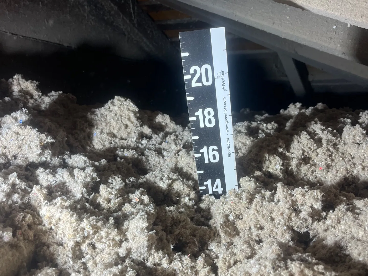 Measuring blown-in insulation depth with ruler showing 18+ inches - NY Energy Project