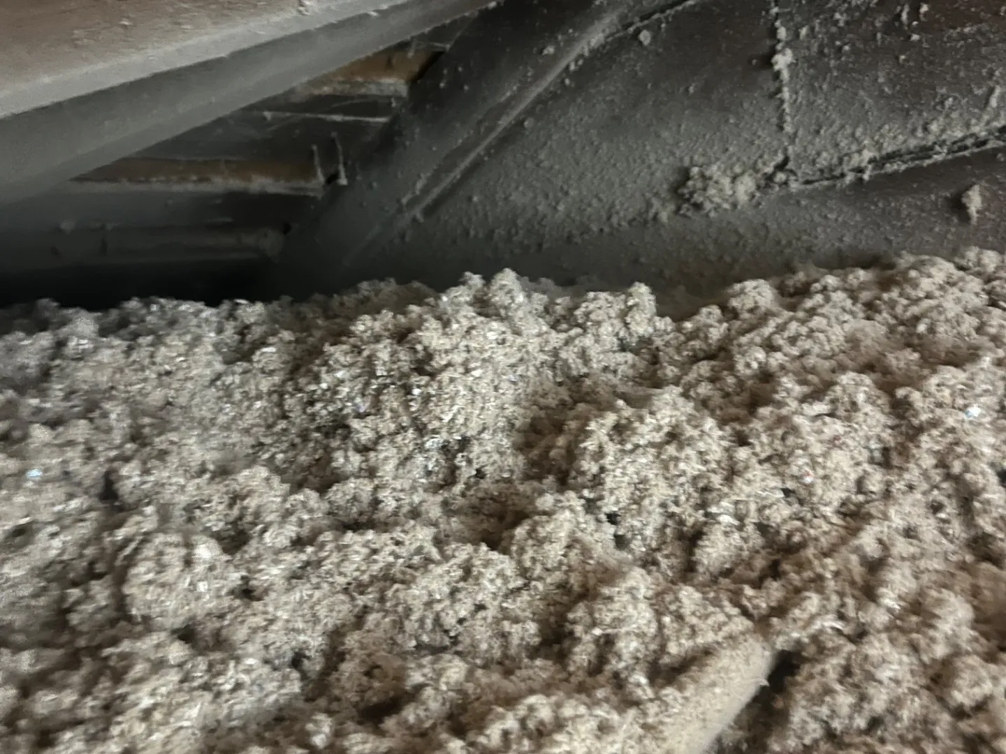 Blown-in insulation filling attic space around rafters - NY Energy Project