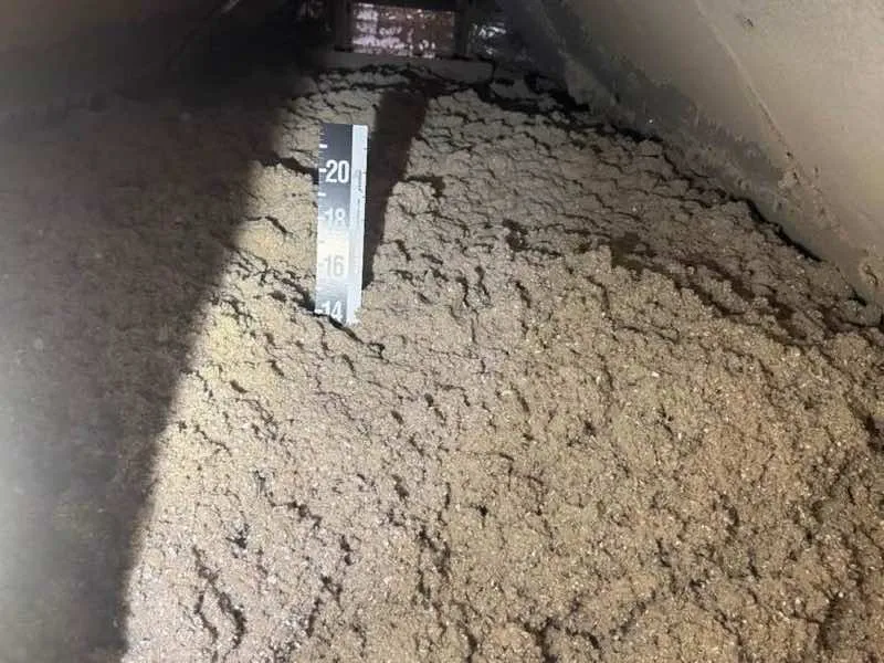 Insulation depth verification in attic with measuring ruler - NY Energy Project