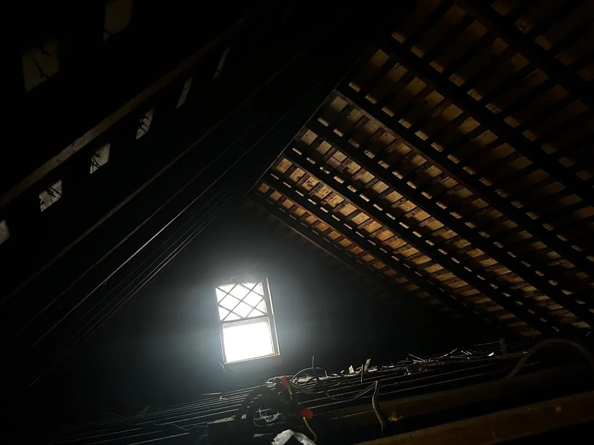 Uninsulated attic in a Queens home showing exposed rafters with no insulation