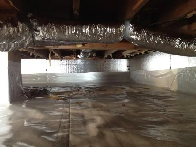 Crawl space with vapor barrier and insulated ductwork after encapsulation - NY Energy Project