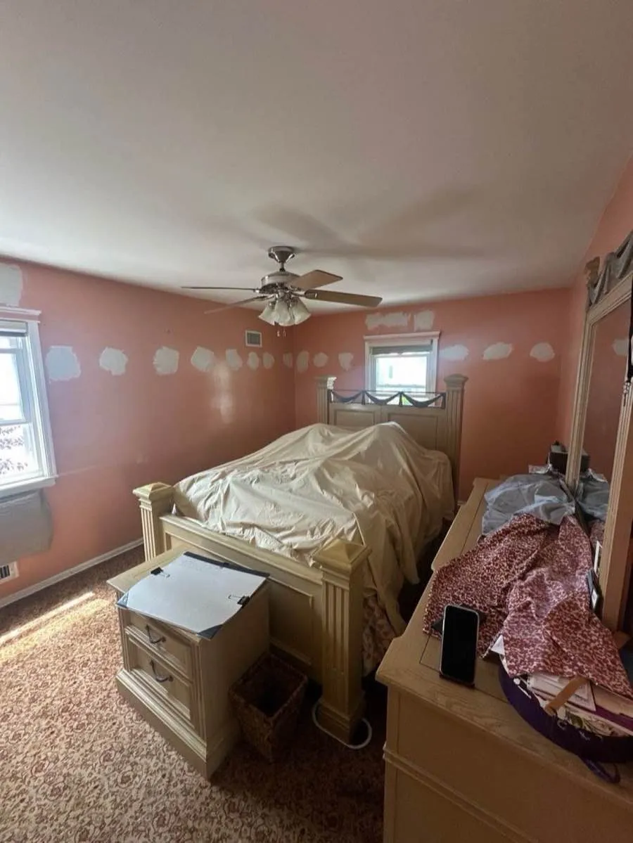 Bedroom with patched walls after dense-pack cellulose insulation installation - NY Energy Project