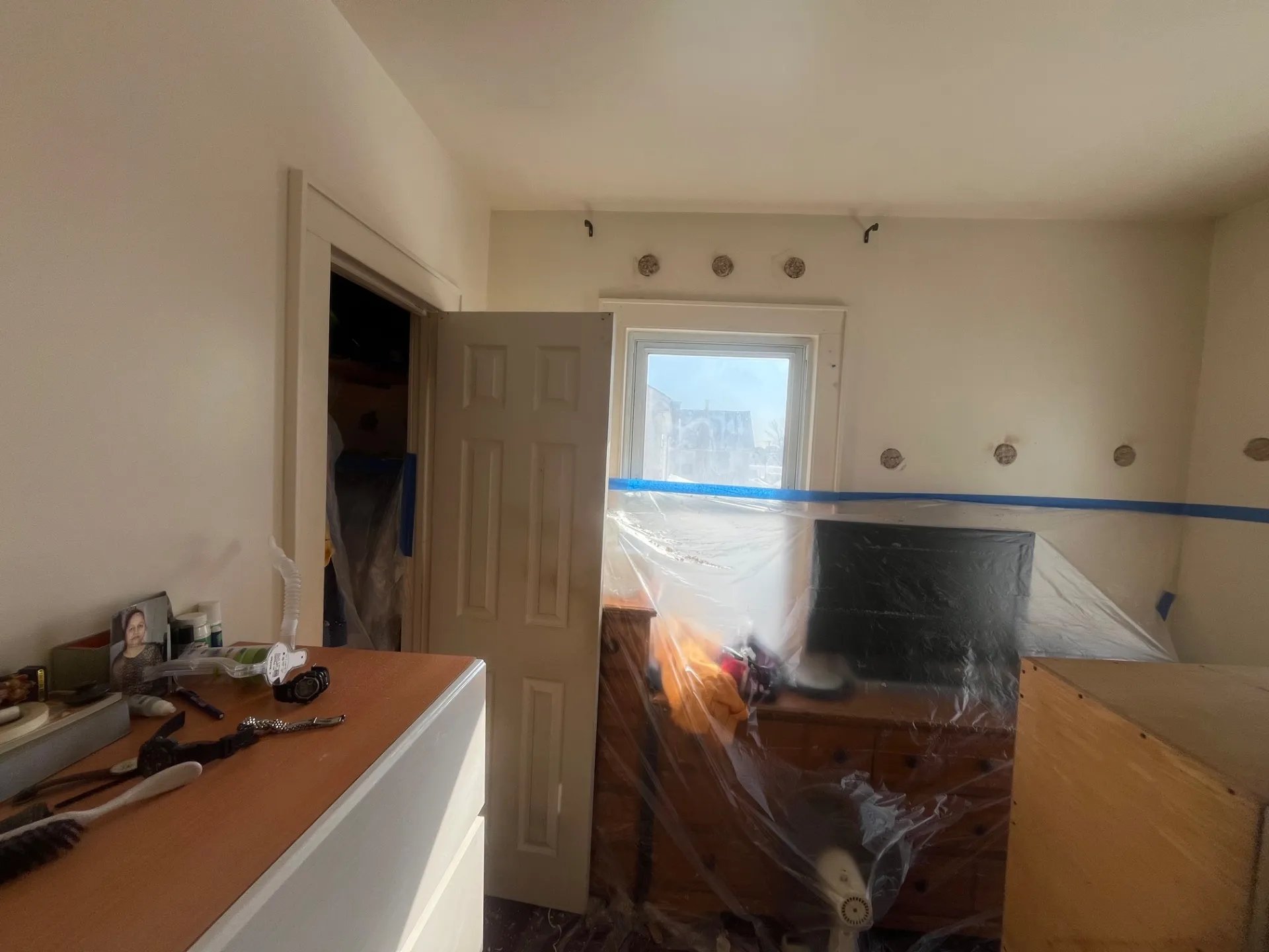 Room prepped with plastic sheeting protecting furniture and floors for interior wall insulation - NY Energy Project